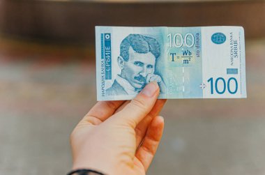 female hand holds a banknote of 100 (one hundred) Serbian dinars