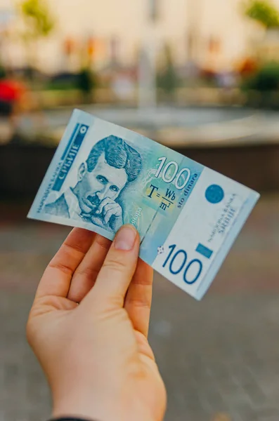 Жіноча рука тримає банкноту 100 (100) Сербський Динара — стокове фото