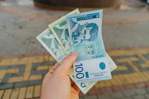 Жіноча рука тримає банкноти 500 (п'ятсот) і 100 (один h — стокове фото
