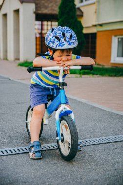 Koruyucu bir kask üç yıl Sevimli çocuk bir runbike sürmek (