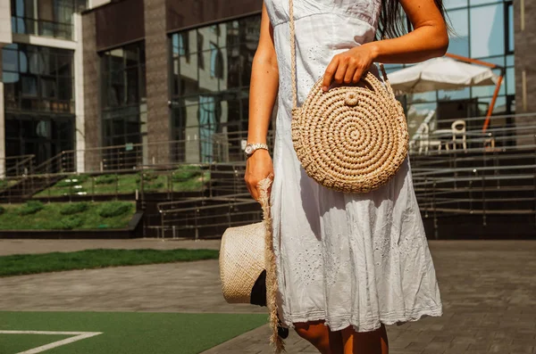 Slanke meisje in een witte Chintz jurk houdt een geweven stro ronde b — Stockfoto