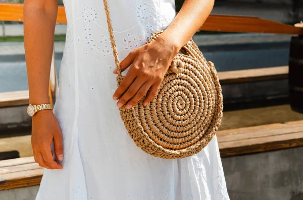 Schlankes Mädchen in weißem Chintz-Kleid hält ein gewebtes Stroh rund b — Stockfoto