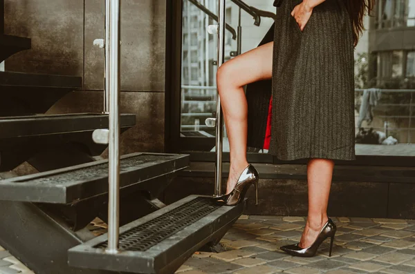 Mooie vrouwelijke benen in metalen schoenen met hoge hakken beklimmen de trap — Stockfoto