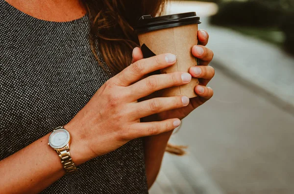 Mano femminile tiene una tazza di carta con caffè . — Foto Stock