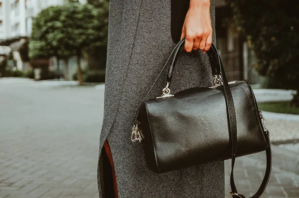 Vrouwelijke hand houdt een vierkante lederen tas. Straat look van een Busines — Stockfoto