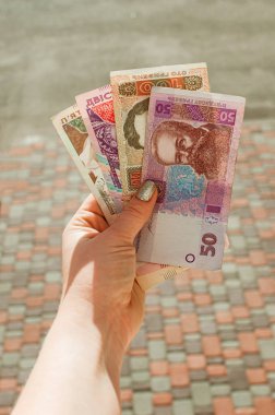 Kadın eli 500, 200, 100, 50 Hryvnia senedi tutuyor.