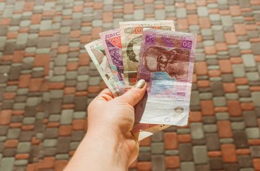 Kadın eli 500, 200, 100, 50 Hryvnia senedi tutuyor.