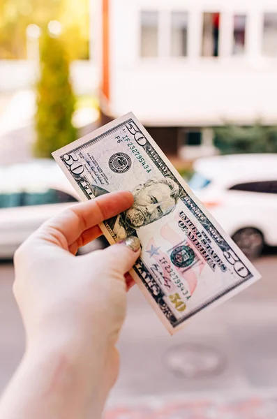 Kobieta trzyma 100 dolarów banknot na tle — Zdjęcie stockowe