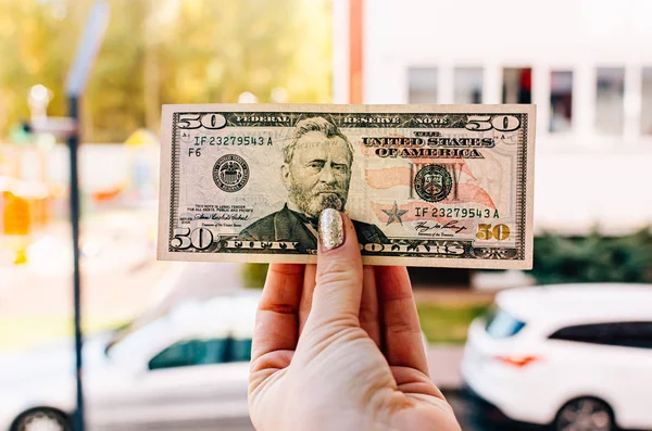 Main féminine détient billet de 100 dollars dans le contexte de la — Photo