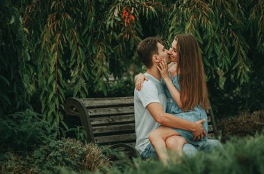 Birbirine aşık güzel bir çift yazın bir bankta oturur.