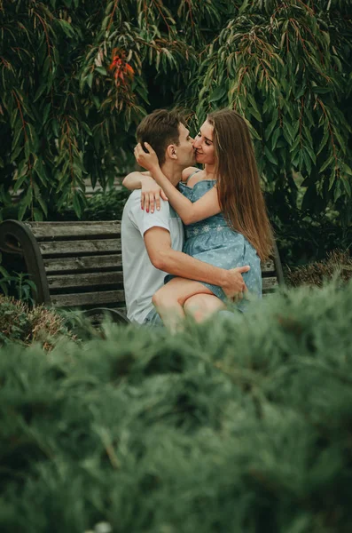 Beau couple amoureux assis dans un parc sur un banc en été — Photo