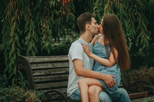 Bella coppia innamorata si siede in un parco su una panchina in estate — Foto Stock
