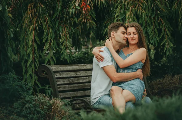 Mooi paar in liefde zit in een park op een bank in de zomer — Stockfoto