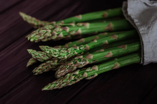 Asparagus. Fresh green asparagus on black  background. Simple, wholesome farm (rural) food