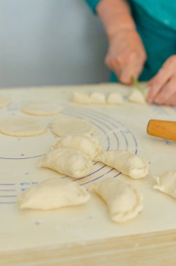 Ev yapımı pierogi heykeli yapma süreci. Büyükannem ulusal bir Ukrayna yemeği hazırlıyor, Vareniki. Seçici odaklanma, yaşam tarzı