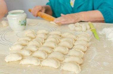 Ev yapımı pierogi heykeli yapma süreci. Büyükannem ulusal bir Ukrayna yemeği hazırlıyor, Vareniki. Seçici odaklanma, yaşam tarzı