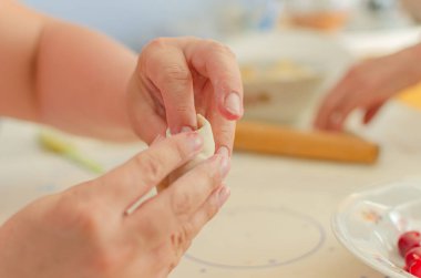 Ev yapımı pierogi heykeli yapma süreci. Büyükannem ulusal bir Ukrayna yemeği hazırlıyor, Vareniki. Seçici odaklanma, yaşam tarzı