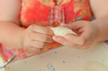 Ev yapımı pierogi heykeli yapma süreci. Büyükannem ulusal bir Ukrayna yemeği hazırlıyor, Vareniki. Seçici odaklanma, yaşam tarzı