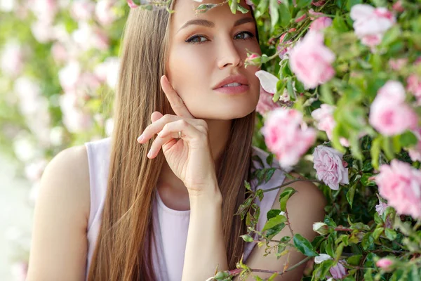 Schöne Frau in Rosen auf der Natur. — Stockfoto