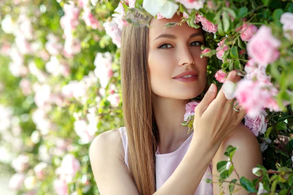 美丽的女人在自然界的玫瑰上. — 图库照片