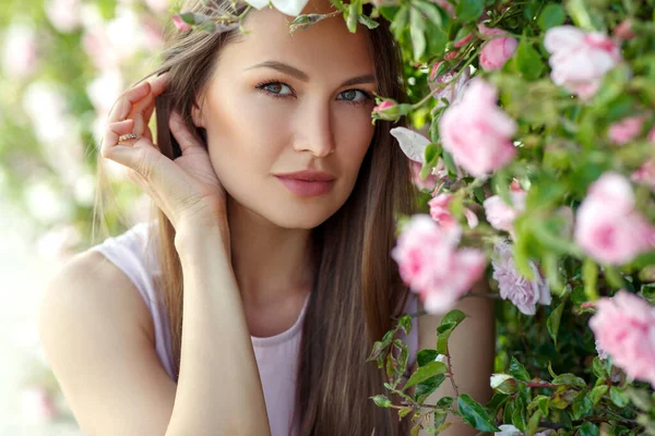 Schöne Frau in Rosen auf der Natur. — Stockfoto