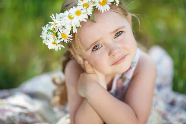 Ein Kind mit einem Blumenkranz. — Stockfoto