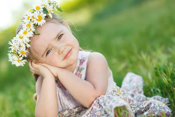 Uma criança com uma coroa de flores . — Fotografia de Stock