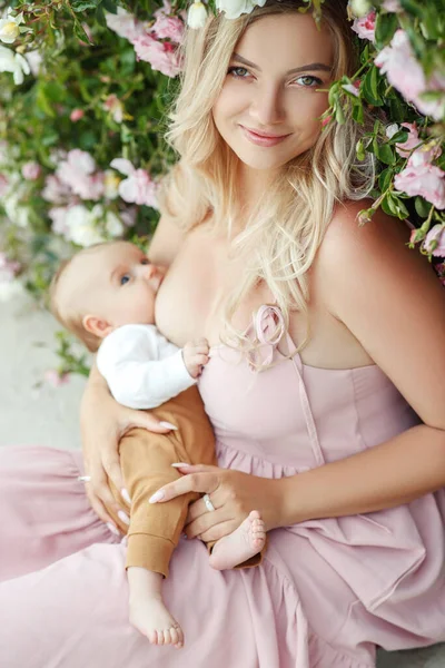 Uma mulher está amamentando um bebê . — Fotografia de Stock