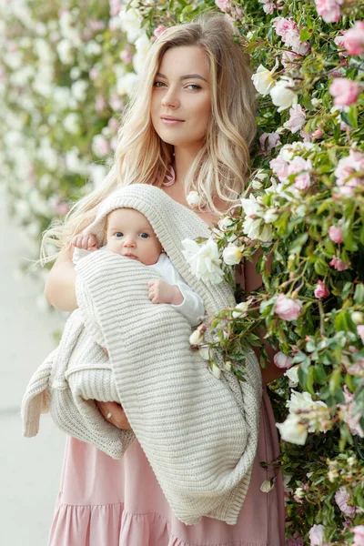 Jonge vrouw met een baby in de natuur. — Stockfoto