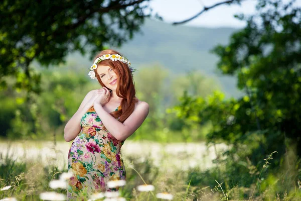 Pregnant woman in nature with flowers. Royalty Free Stock Images