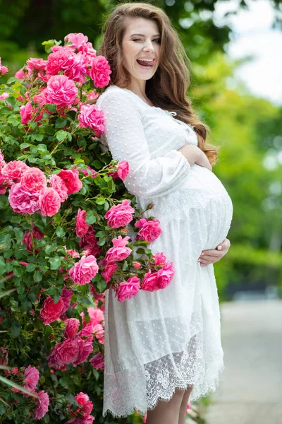 Zwangere vrouw in de natuur met bloemen. — Stockfoto