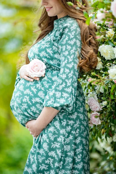 Zwangere vrouw in de natuur met bloemen. — Stockfoto