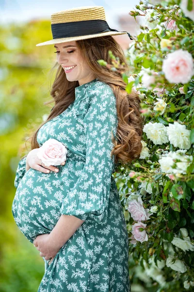 Zwangere vrouw in de natuur met bloemen. — Stockfoto