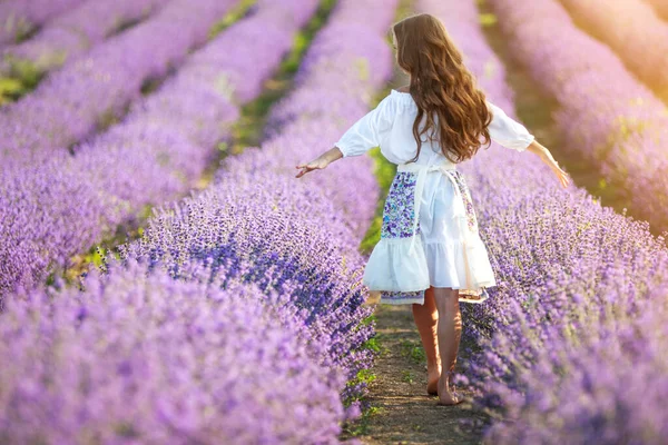 Vacker flicka på ett fält med lavendel. — Stockfoto