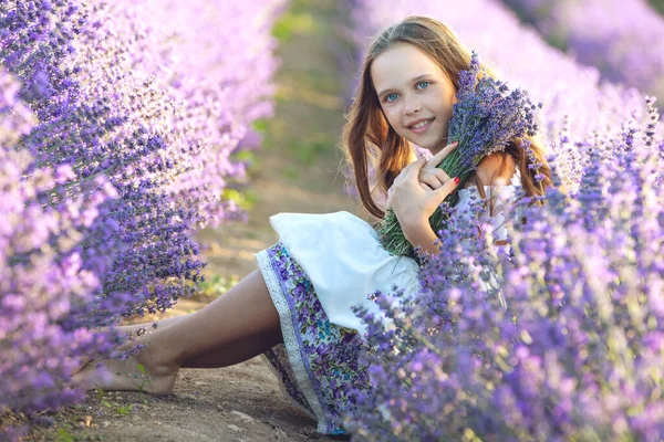 Vacker flicka på ett fält med lavendel. — Stockfoto