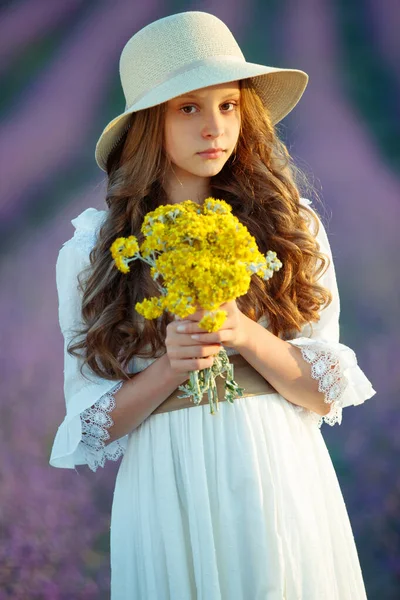 Mooi meisje in een veld met lavendel. — Stockfoto