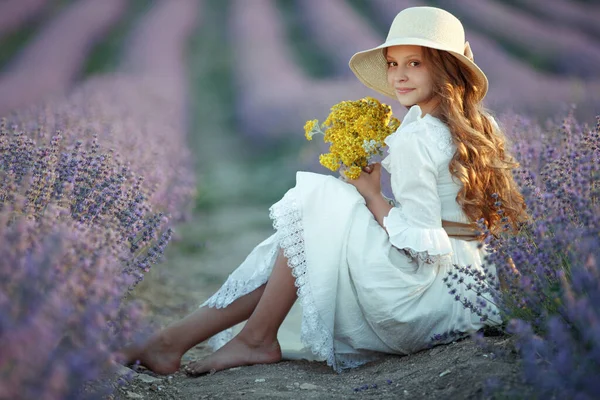 Vacker flicka på ett fält med lavendel. — Stockfoto