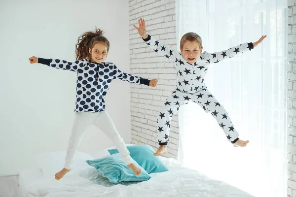 Children jump on the bed.