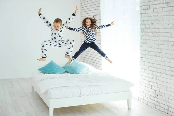 Children jump on the bed.