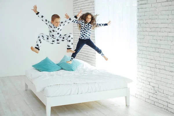 Children jump on the bed.