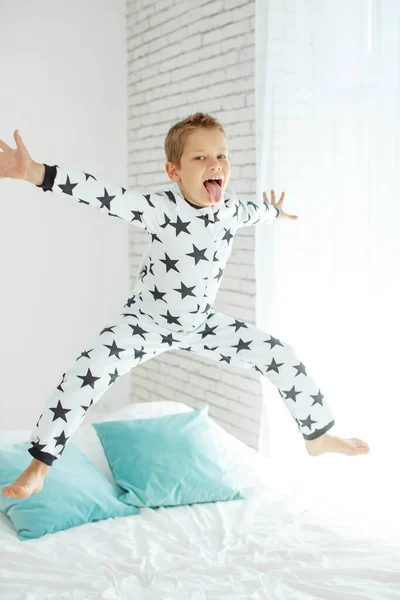 Copilul pe pat în pijamale . — Fotografie, imagine de stoc