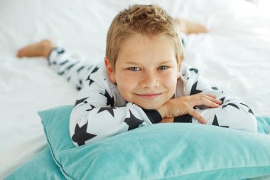 Yatakta pijamalı bir çocuk.