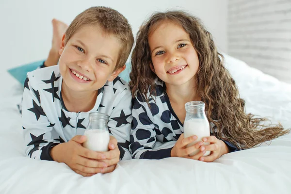 I bambini bevono latte. Ragazzo e ragazza a casa. — Foto Stock