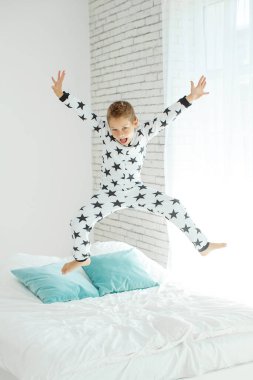 Yatakta pijamalı bir çocuk.