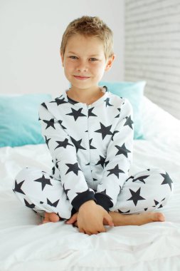 Yatakta pijamalı bir çocuk.