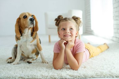 Köpekli bir çocuk. Küçük kız evde bir köpekle oynuyor. Çocuk ve hayvan.
