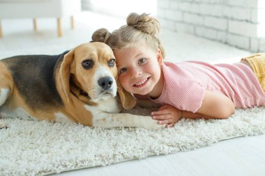 Köpekli bir çocuk. Küçük kız evde bir köpekle oynuyor. Çocuk ve hayvan.