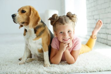 Köpekli bir çocuk. Küçük kız evde bir köpekle oynuyor. Çocuk ve hayvan.