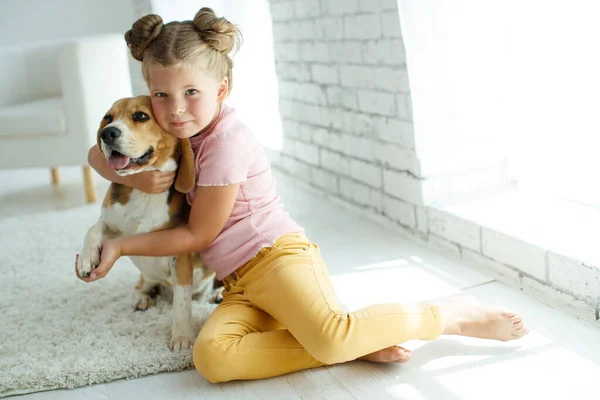 Un niño con un perro. La niña juega con un perro en casa. Niño y animal. — Foto de Stock