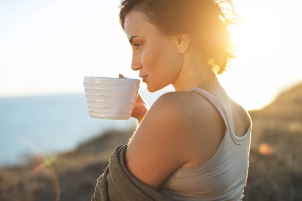 Красива жінка п'є каву. Жінка на відкритому повітрі . — стокове фото